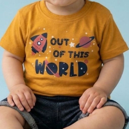 Child wearing a yellow shirt with text and graphics on a light blue background