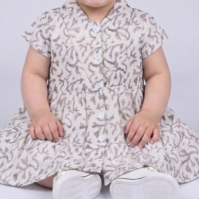 Child wearing a floral dress with a plain background
