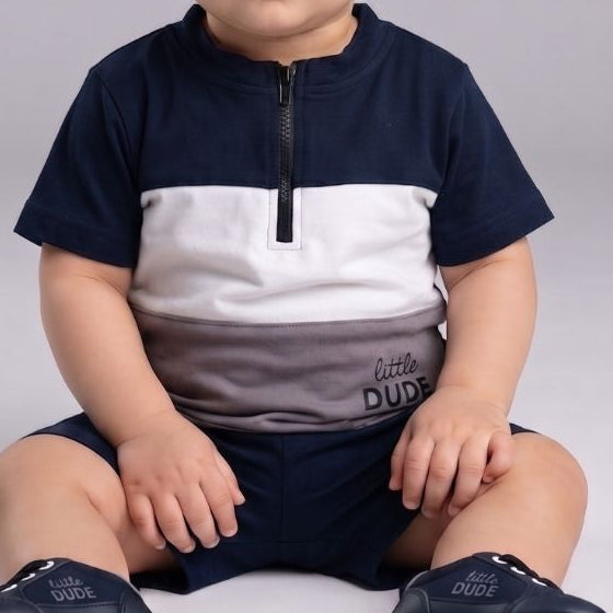 Child wearing a navy and white outfit with matching shoes on a gray background