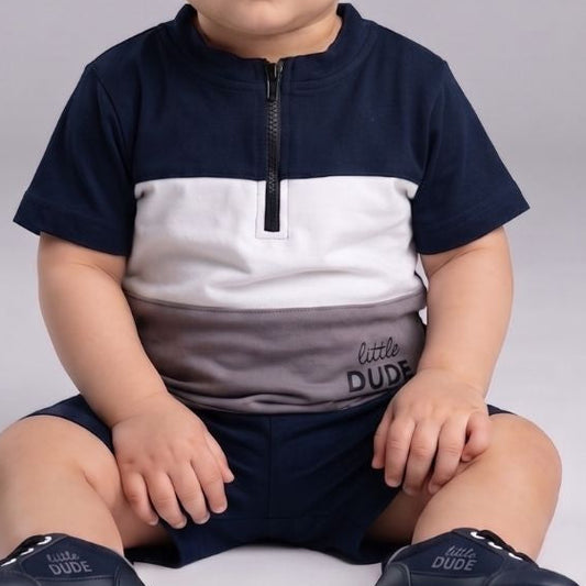 Child wearing a navy and white outfit with matching shoes on a gray background