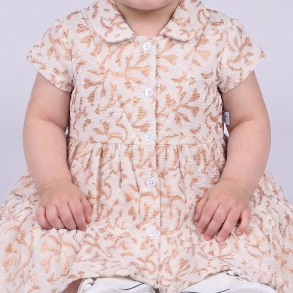 Child wearing a floral dress with a plain background