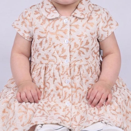 Child wearing a floral dress with a plain background