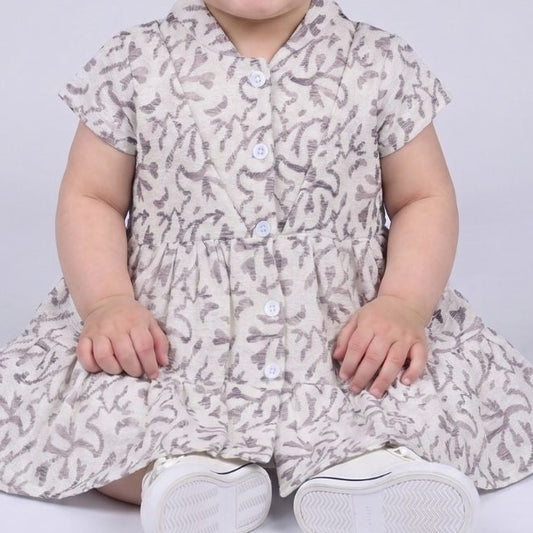Child wearing a floral dress with a plain background
